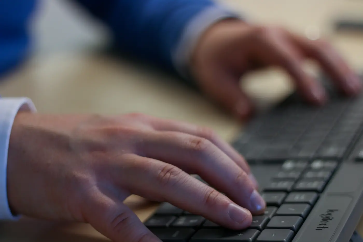 Handen op het toetsenbord tijdens werk aan een website