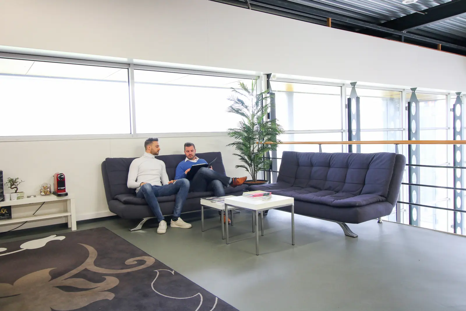 Sjoerd en Tom in overleg in de zithoek op kantoor